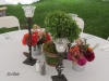 Low dinner table design with herbs and wild flowers finished with wrought iron candel stick holders
